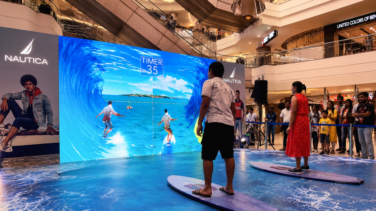 People engaging with a gesture-controlled surfing game at an interactive mall activatio
